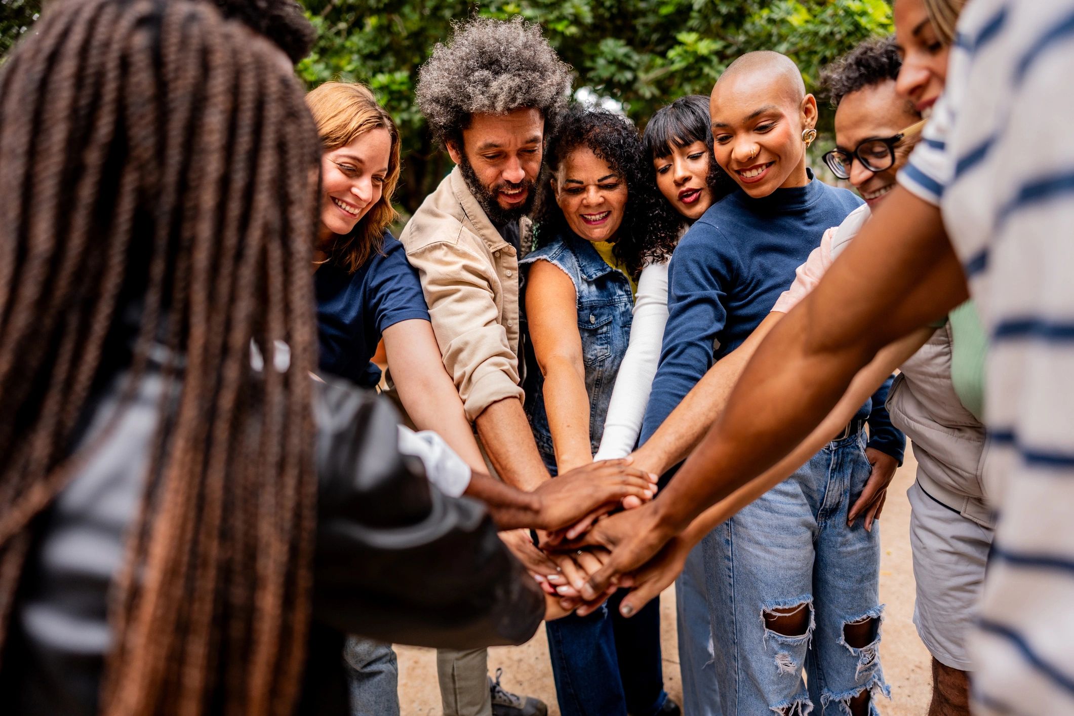 Community members joining hands outdoors