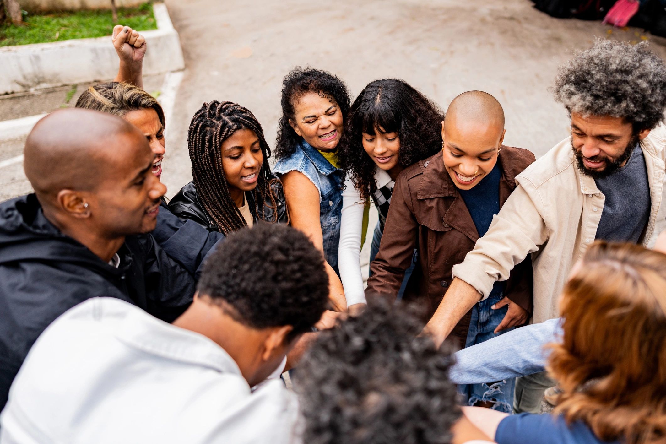 Community members joining hands outdoors