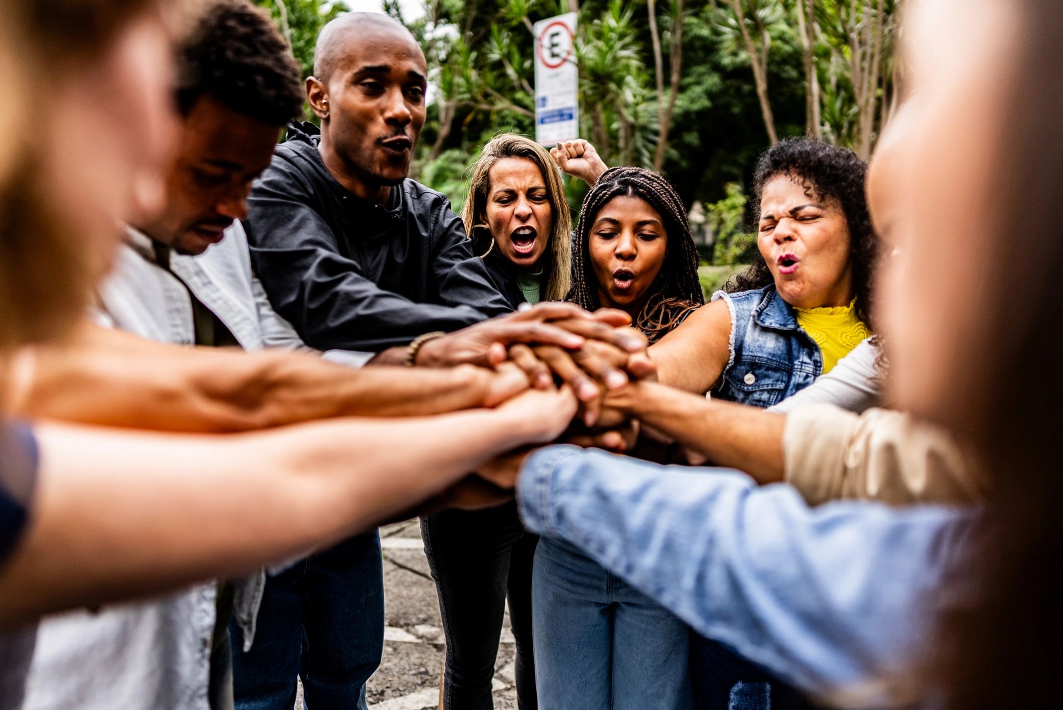 Community members stacking hands together outdoors
